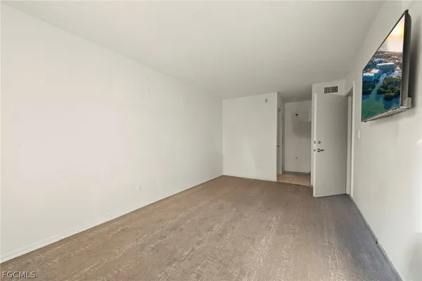 a view of a livingroom with an empty space and a window