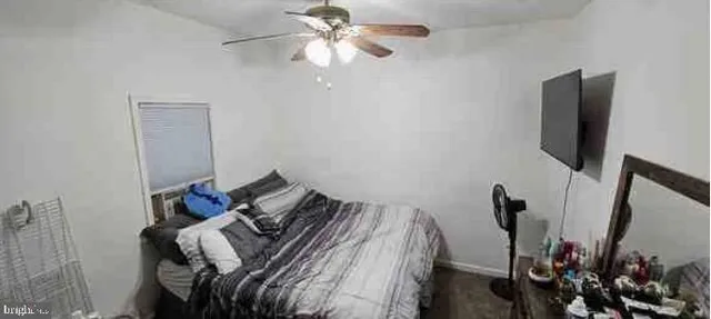 a bedroom with a bed and a flat tv screen on the dresser