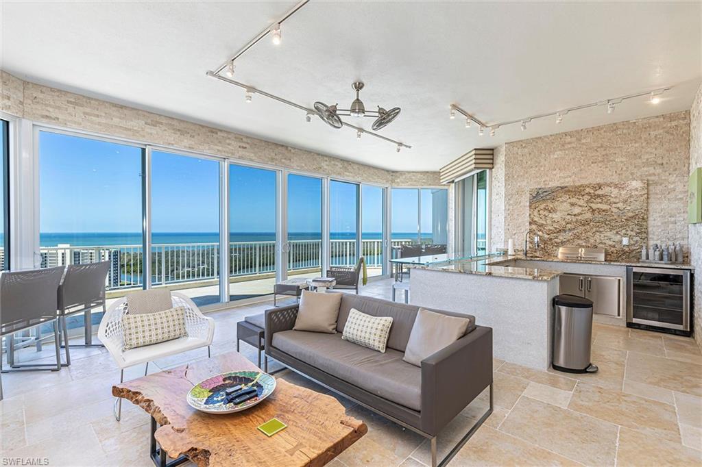 295 Grande Way, Unit PH2 Naples, FL 34110 - Photo 19 of 45 a living room with furniture a large window and a dining table