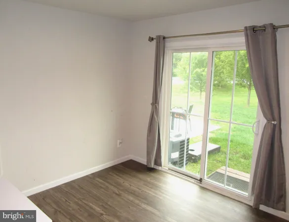 a view of an empty room and wooden floor and walls