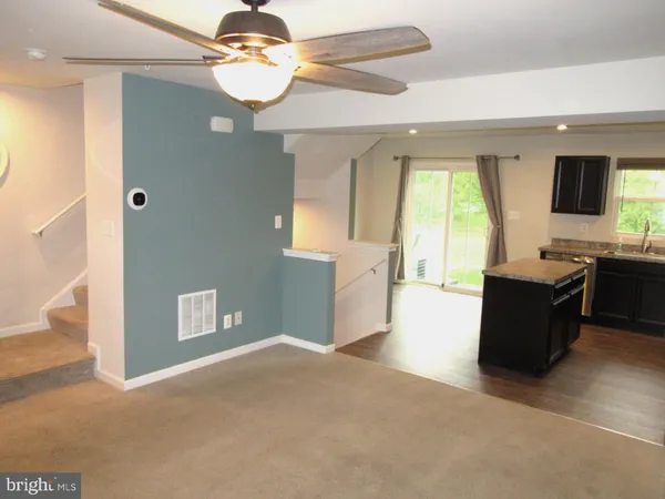 a living room with kitchen island furniture and a chandelier