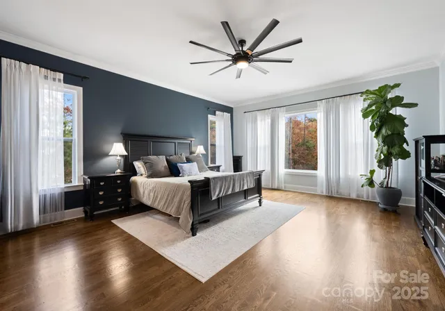 a spacious bedroom with a bed a couch and a large window