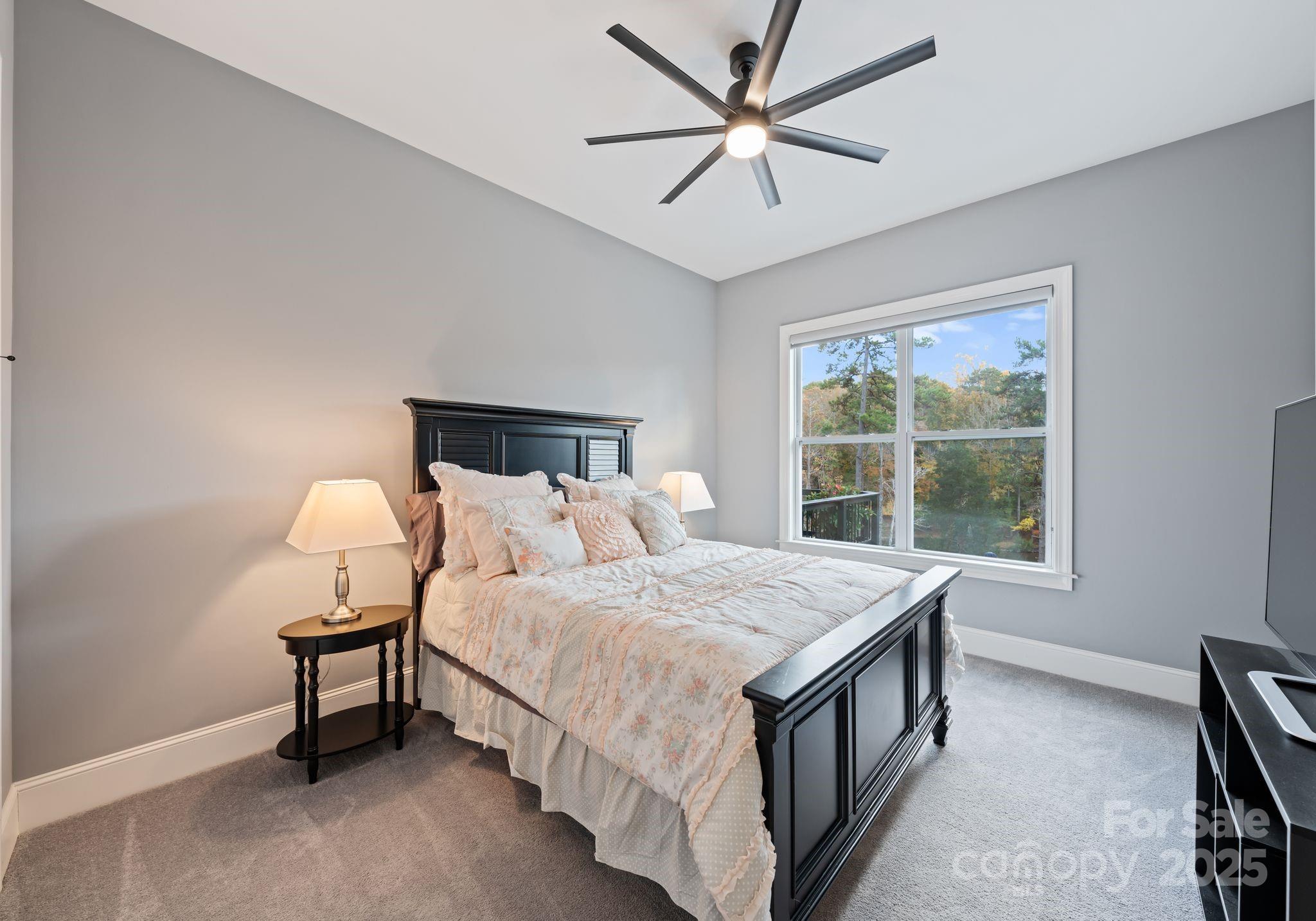 16312 Cozy Cove Road Charlotte, NC 28278 - Photo 20 of 48 a bedroom with a bed a chandelier and a window
