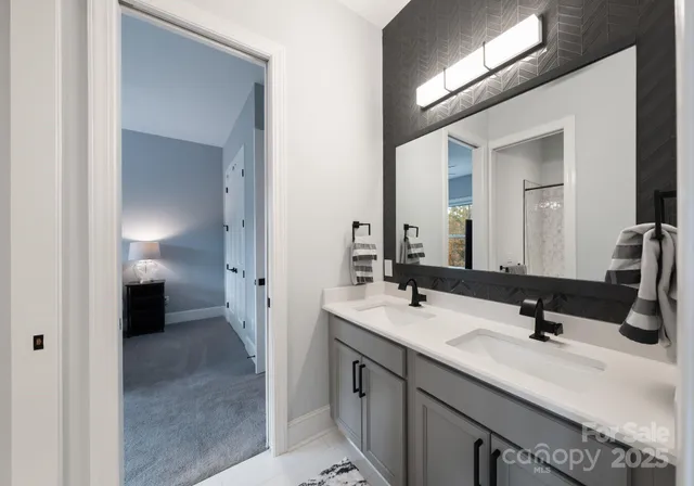 a en suite bathroom with a double vanity sink and a mirror