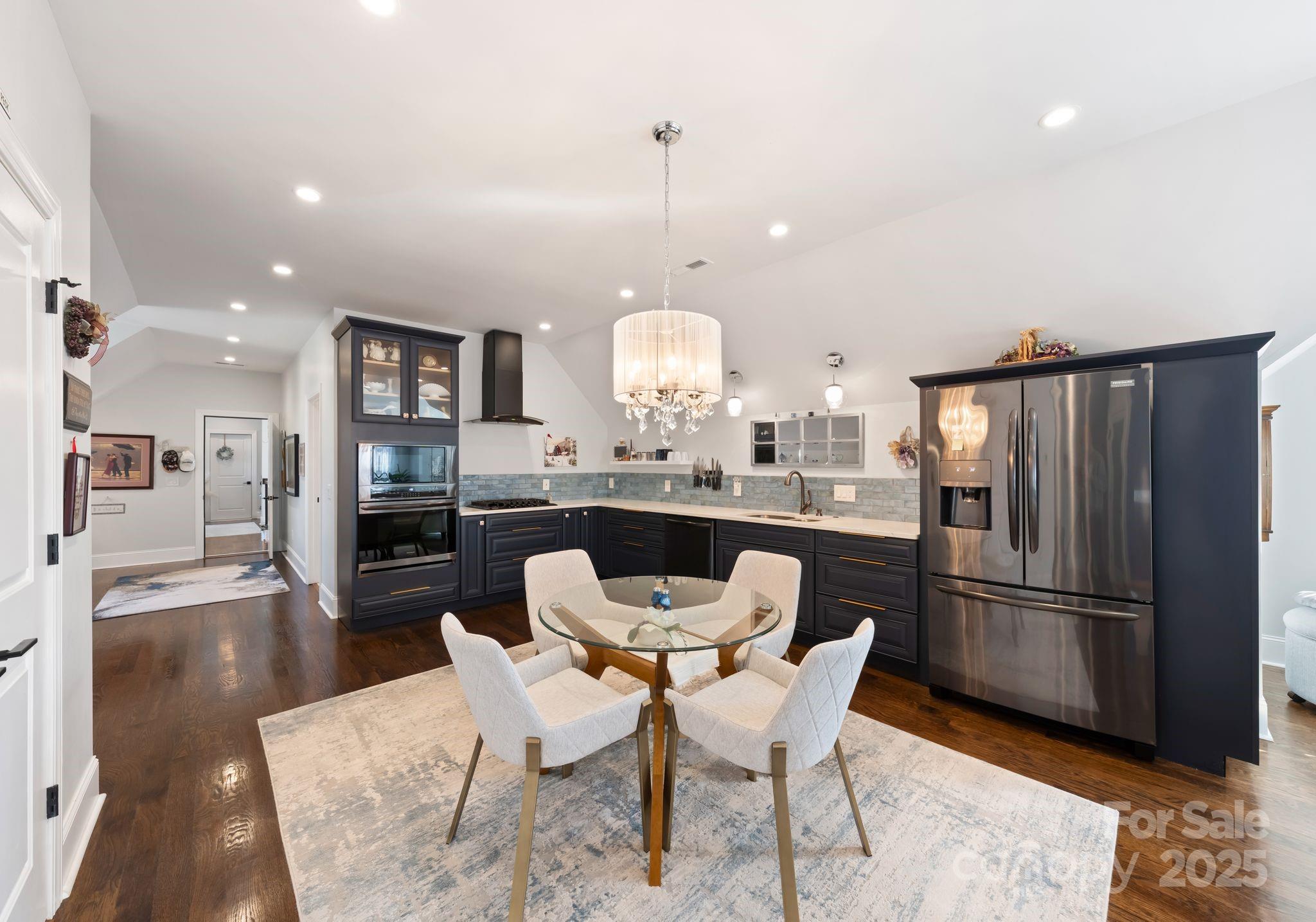 16312 Cozy Cove Road Charlotte, NC 28278 - Photo 25 of 48 a view of a dining room with furniture a chandelier and wooden floor