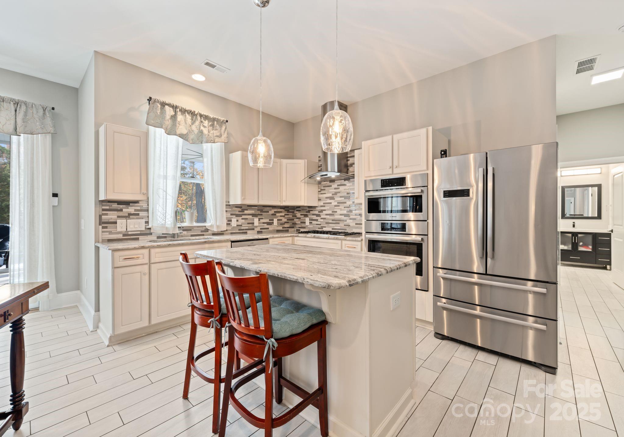 16312 Cozy Cove Road Charlotte, NC 28278 - Photo 30 of 48 a kitchen with stainless steel appliances a refrigerator a stove a sink and white cabinets with wooden floor