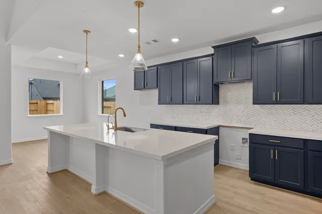 a kitchen with kitchen island a sink stainless steel appliances and cabinets
