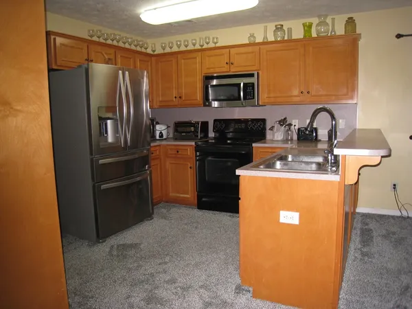 a kitchen with stainless steel appliances granite countertop a refrigerator stove and a sink