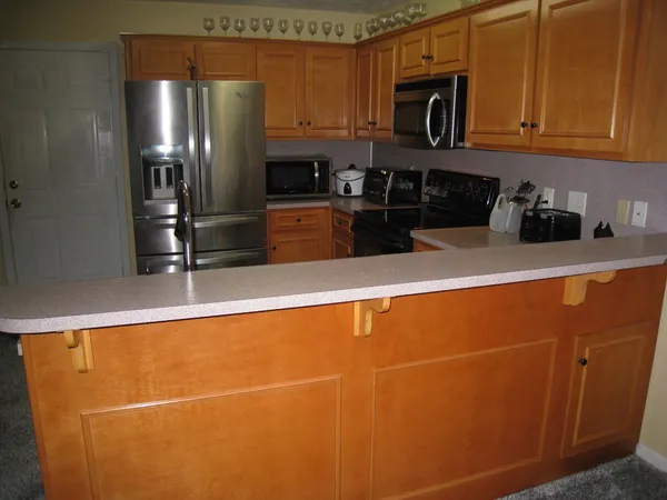 a kitchen with stainless steel appliances a refrigerator a sink a stove top oven and cabinets