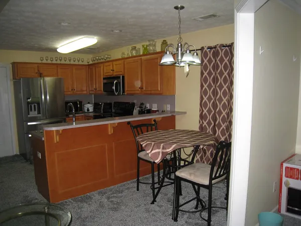 a kitchen with stainless steel appliances granite countertop a sink refrigerator and microwave