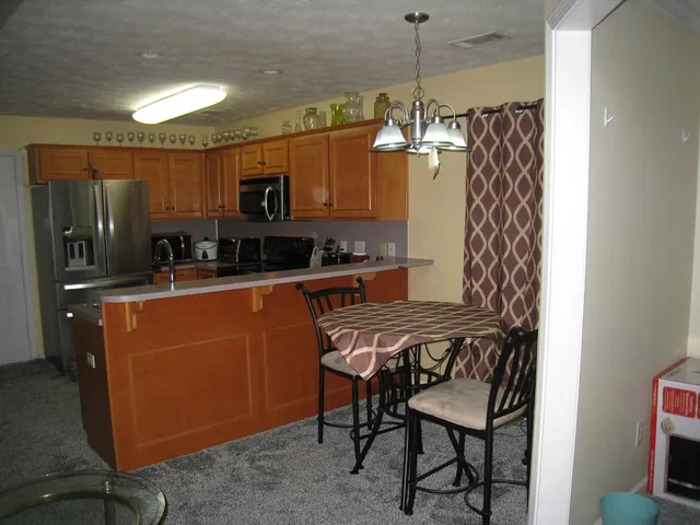 a kitchen with stainless steel appliances granite countertop a sink refrigerator and microwave