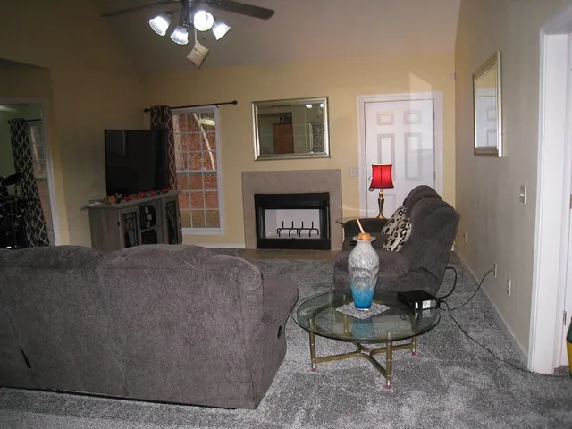 a living room with furniture a fireplace and a flat screen tv