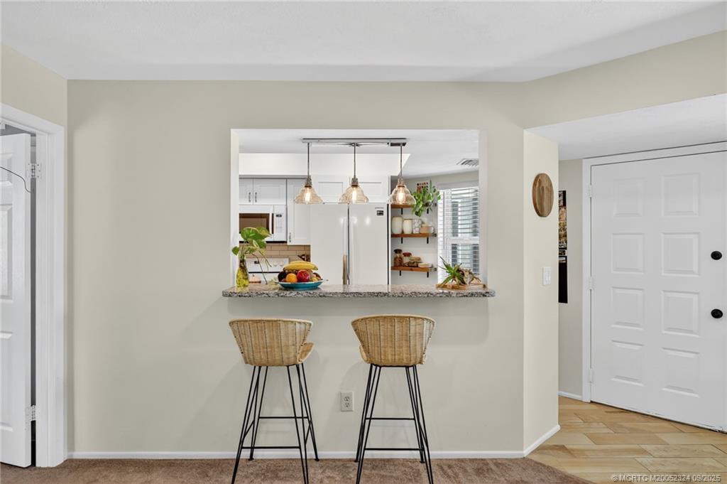 3260 Southeast Aster Lane, Unit I241 Stuart, FL 34994 - Photo 11 of 48 a room with a table and chairs