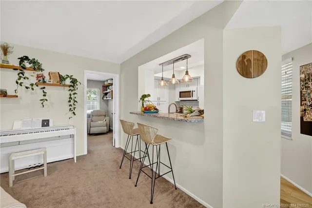 a kitchen with granite countertop a sink stainless steel appliances white cabinets and a window