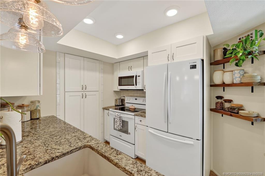 3260 Southeast Aster Lane, Unit I241 Stuart, FL 34994 - Photo 15 of 48 a kitchen with a refrigerator and a stove top oven