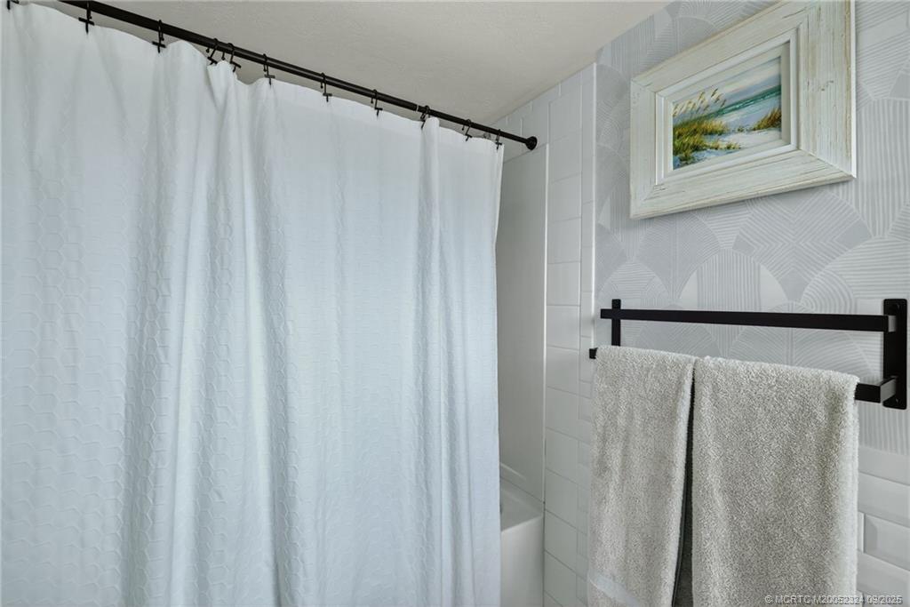3260 Southeast Aster Lane, Unit I241 Stuart, FL 34994 - Photo 21 of 48 a bathroom with a shower and a curtain
