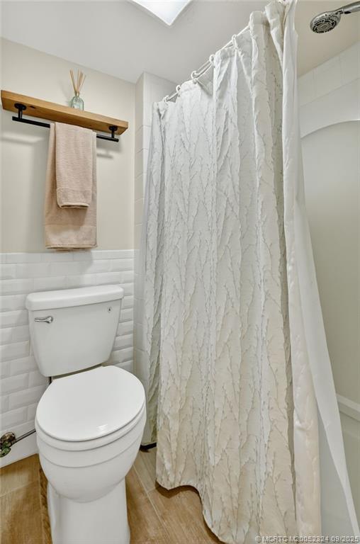 3260 Southeast Aster Lane, Unit I241 Stuart, FL 34994 - Photo 29 of 48 a white toilet sitting next to a shower curtain