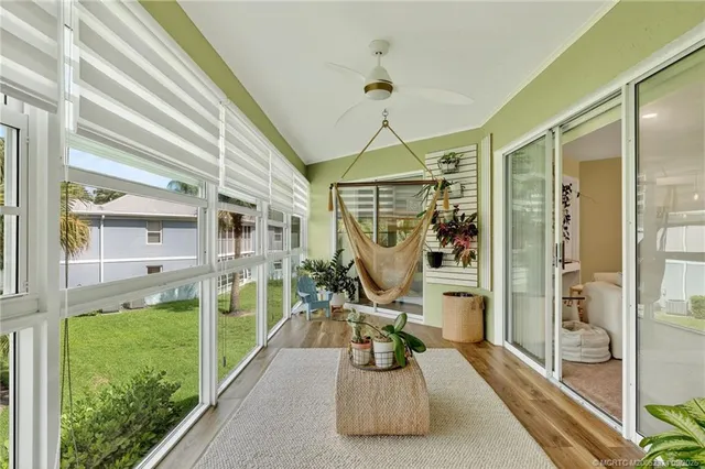 a living room with patio furniture and a potted plant