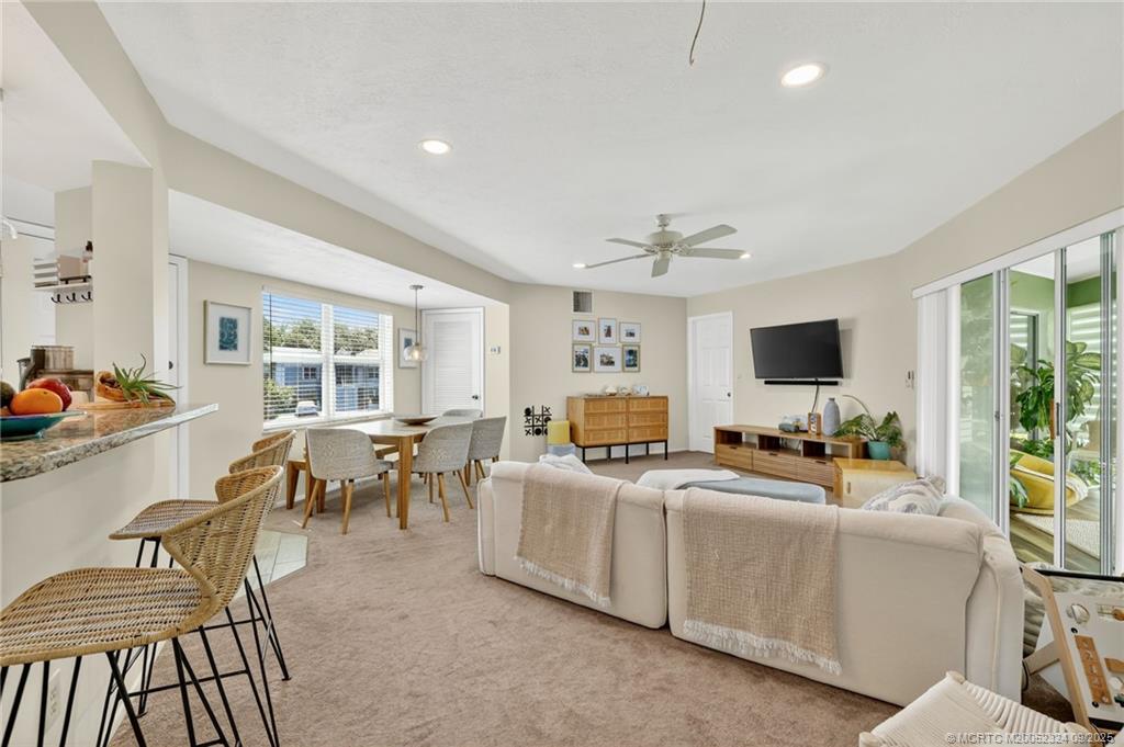 3260 Southeast Aster Lane, Unit I241 Stuart, FL 34994 - Photo 4 of 48 a living room with furniture and a flat screen tv