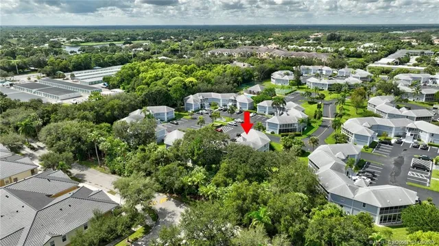 an aerial view of residential houses with outdoor space and trees
