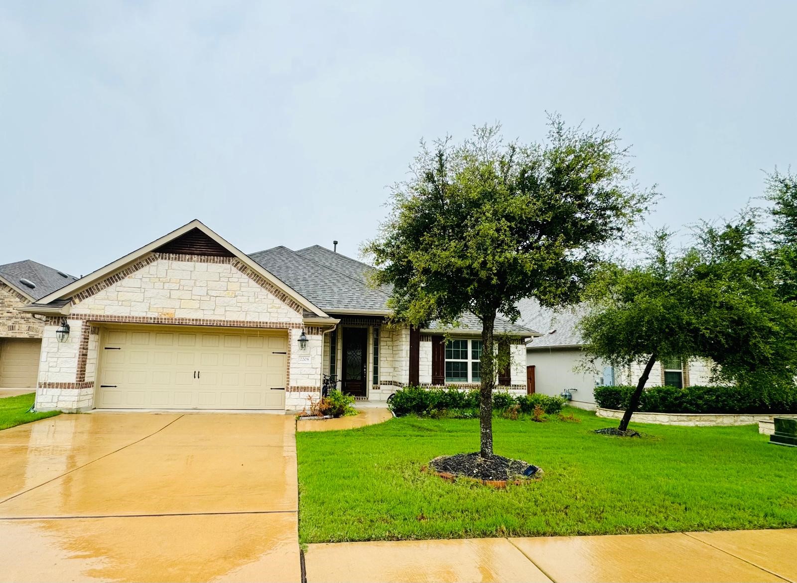 a view of a big house with a big yard and large tree