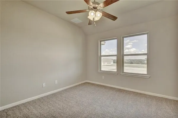 an empty room with a window and a fan