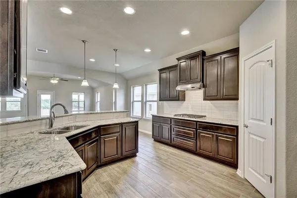 a kitchen with stainless steel appliances granite countertop wooden cabinets and sink