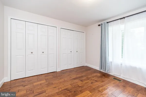 a view of a big room with wooden floor and closet in a room