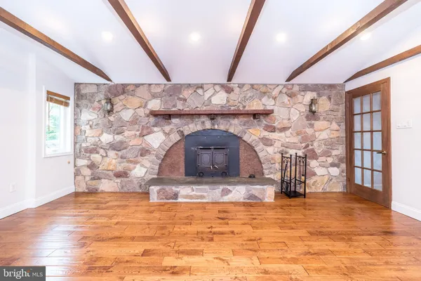 a kitchen with stainless steel appliances granite countertop a sink a stove a refrigerator and island with wooden floor