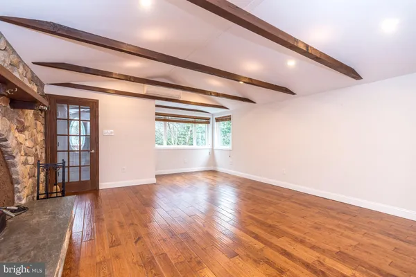 a kitchen with stainless steel appliances granite countertop a refrigerator a sink dishwasher a stove and white cabinets with wooden floor