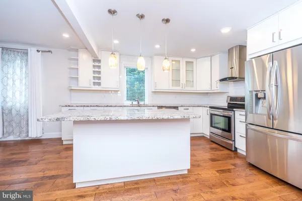 a kitchen with granite countertop a sink stainless steel appliances and cabinets