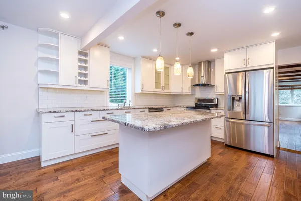 a kitchen with stainless steel appliances granite countertop a sink stove and cabinets