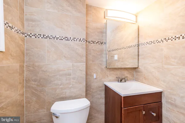 a bathroom with a sink mirror and a toilet