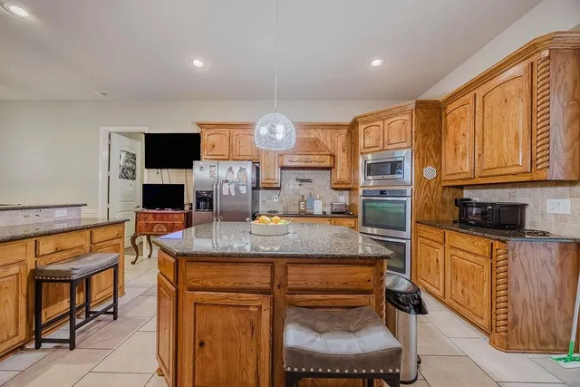 a kitchen with stainless steel appliances granite countertop a stove a sink and a refrigerator