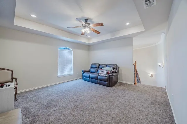 a living room with furniture and a ceiling fan