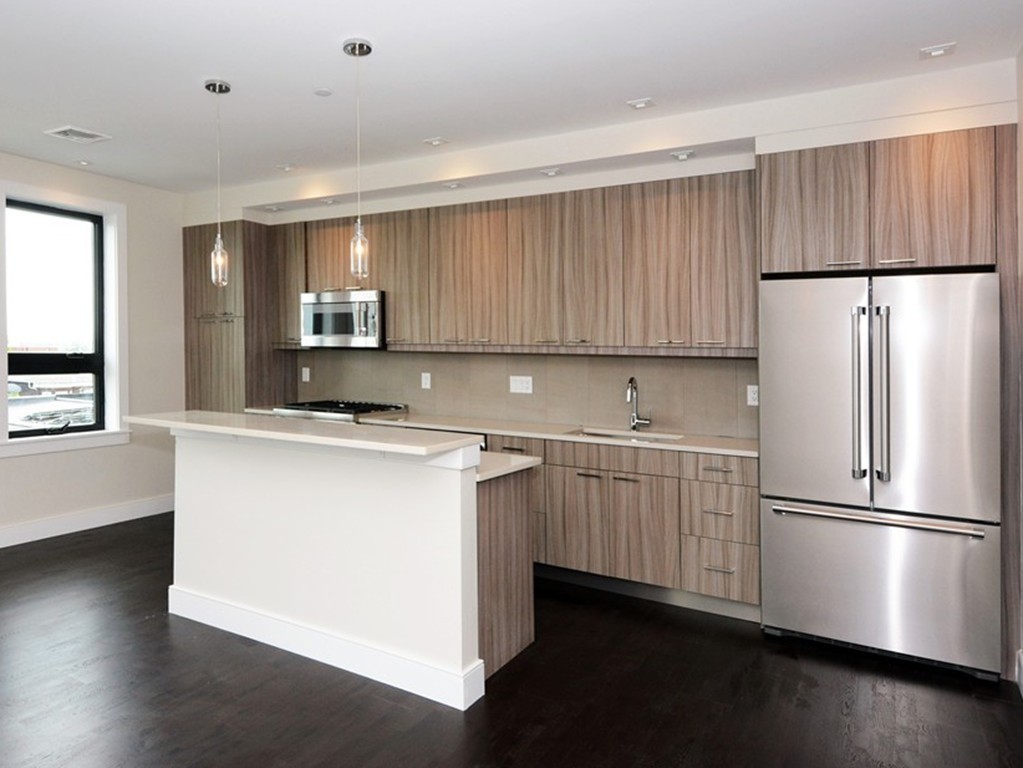 511 East 5th Street, Unit 2 Boston, MA 02127 - Photo 3 of 11 a kitchen with stainless steel appliances a refrigerator sink and microwave