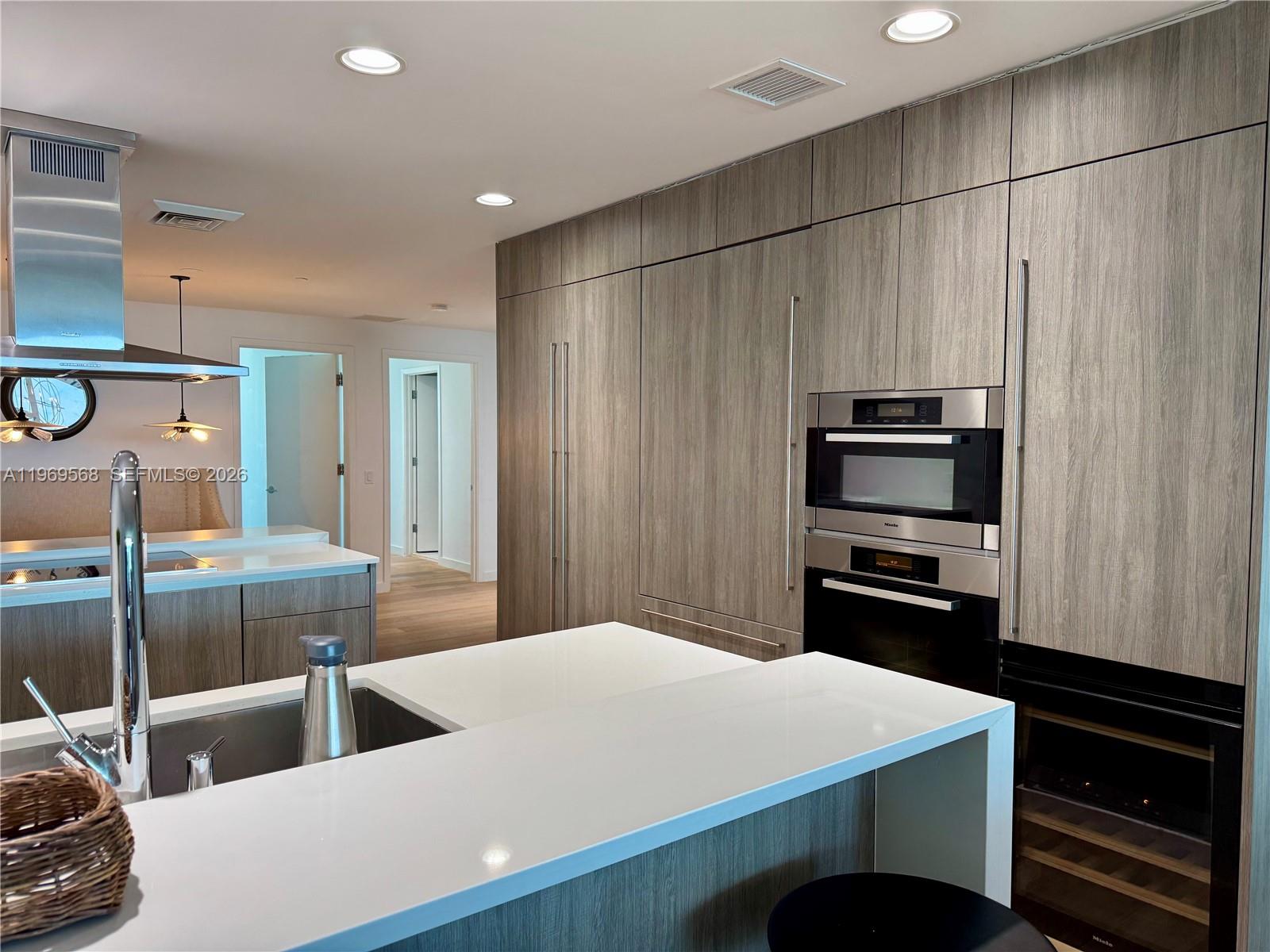 350 Ocean Drive, Unit 406N Key Biscayne, FL 33149 - Photo 13 of 41 a kitchen with kitchen island a counter appliances and cabinets