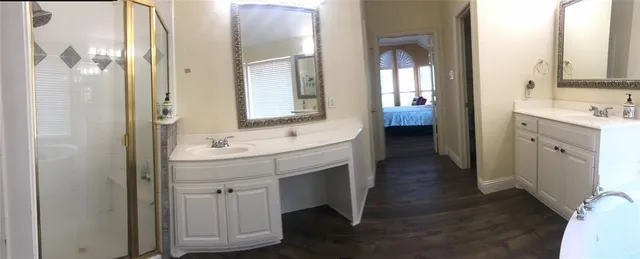 a bathroom with a tub sink shower and mirror