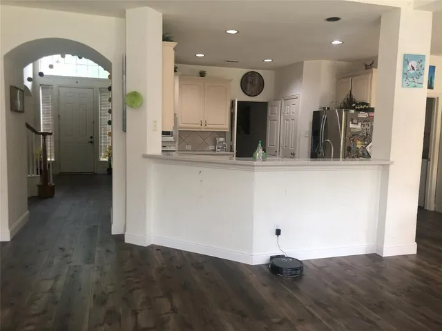 a kitchen with stainless steel appliances kitchen island granite countertop a refrigerator and a stove top oven