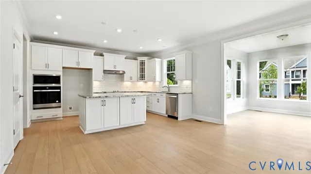 a kitchen with kitchen island white cabinets and refrigerator