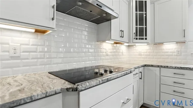 a kitchen with granite countertop a sink a stove and cabinets