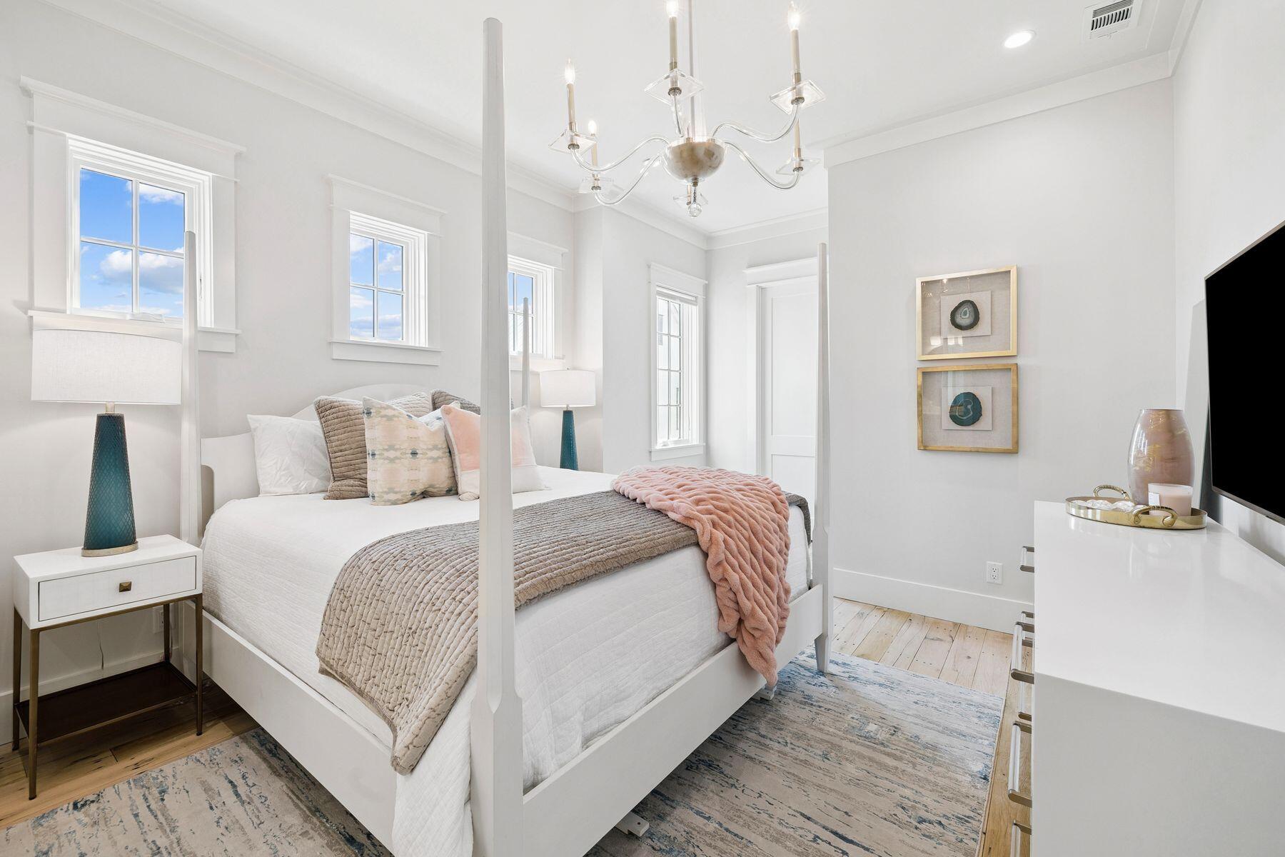 25 Peace Ln Inlet Beach Inlet Beach, FL 32461 - Photo 52 of 85 a bedroom with a bed a flat screen tv and a chandelier