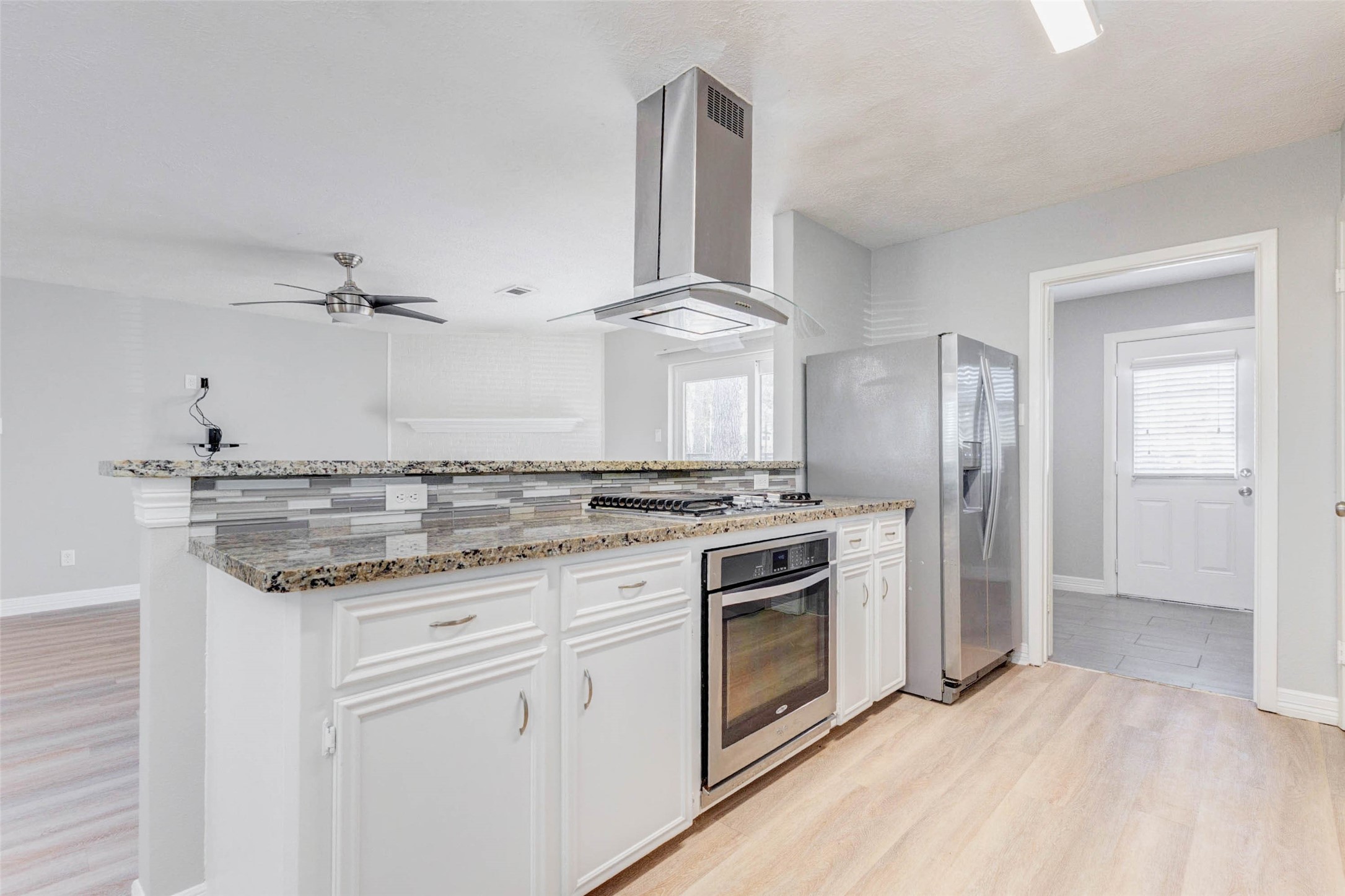 18526 Fenske Road Cypress, TX 77433 - Photo 12 of 32 The peninsula includes a gas cooktop with a stainless vent hood above and a single oven below, allowing easy interaction with guests while preparing meals.