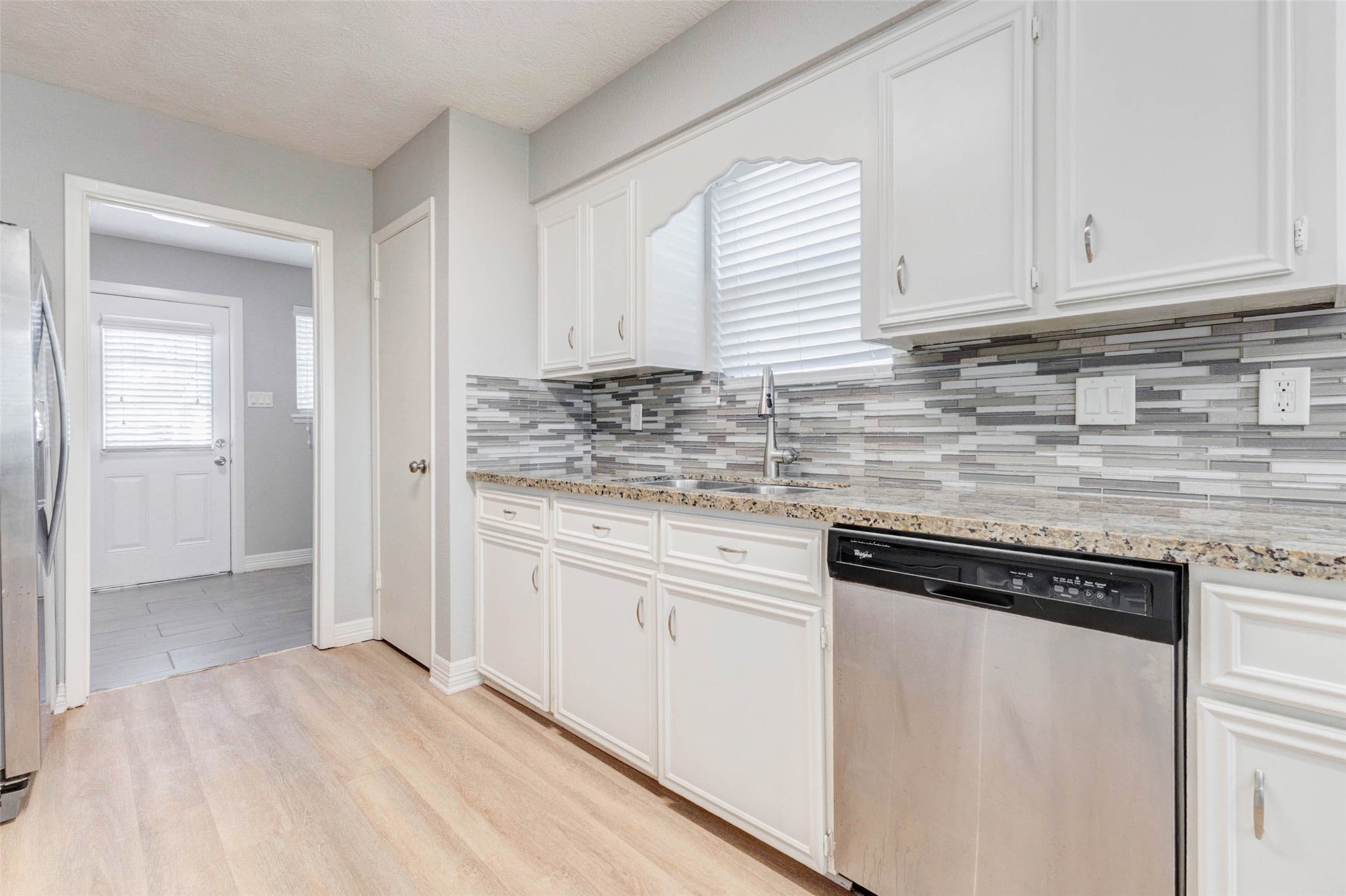 18526 Fenske Road Cypress, TX 77433 - Photo 13 of 32 Opposite the cooking area is an undermount sink positioned beneath a large window with the dishwasher to the right. A spacious pantry is located to the left of the sink.
