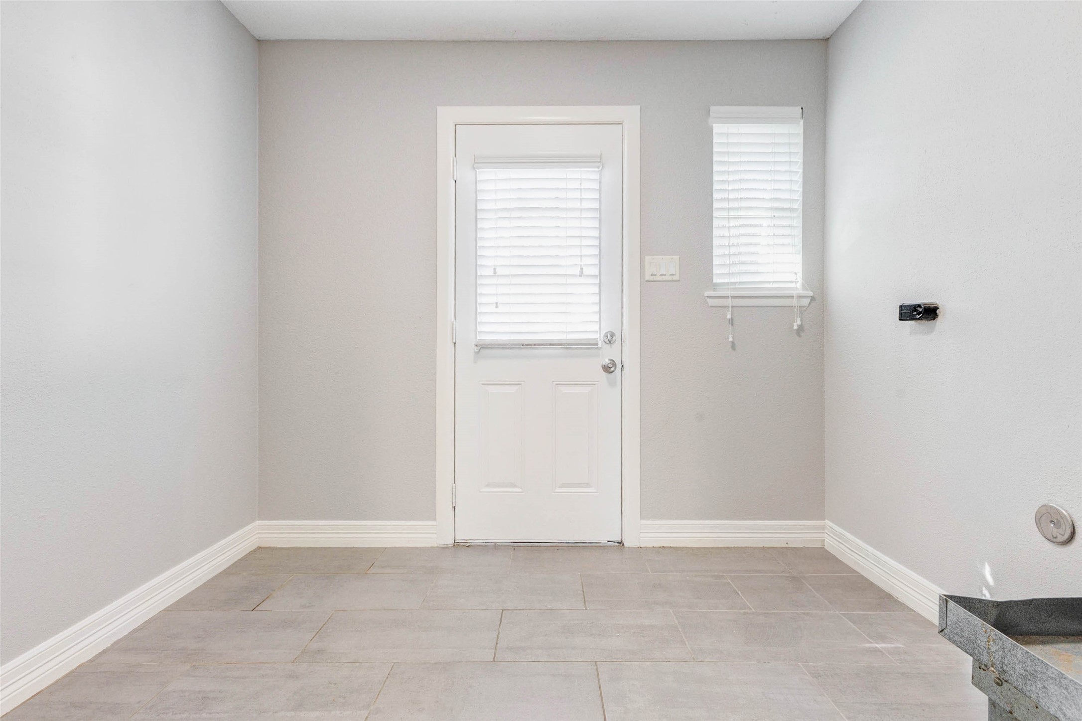 18526 Fenske Road Cypress, TX 77433 - Photo 17 of 32 Just off the kitchen is a spacious mudroom featuring neutral paint, tile flooring, and a door leading to the backyard.