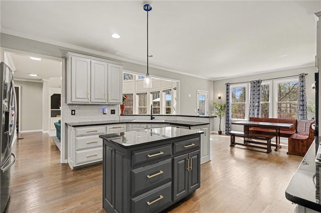 1958 Mapmaker Drive Northeast Dacula, GA 30019 - Photo 14 of 35 a kitchen with a stove a sink a center island and a wooden floor