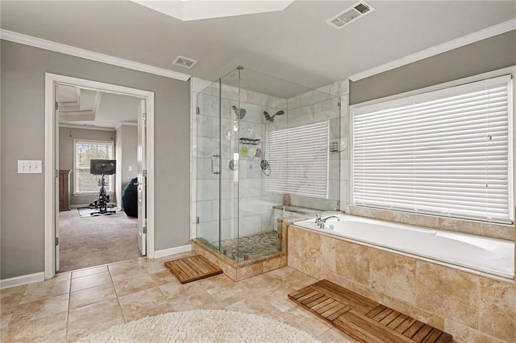 1958 Mapmaker Drive Northeast Dacula, GA 30019 - Photo 19 of 35 a spacious bathroom with a tub shower and sink