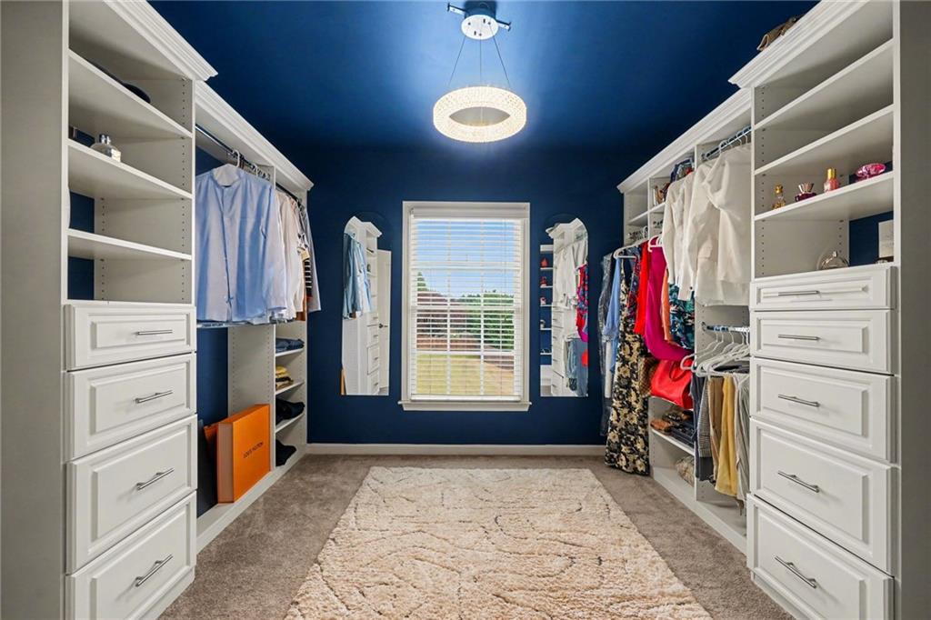 1958 Mapmaker Drive Northeast Dacula, GA 30019 - Photo 21 of 35 a view of walk in closet with clothes and shoes