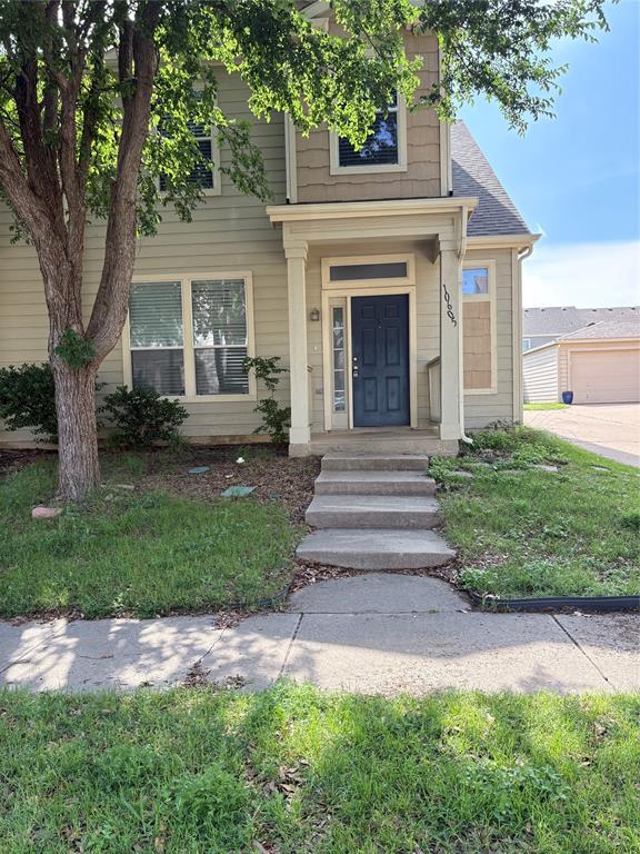 a front view of a house with a yard and an trees