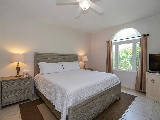 a bedroom with a bed and a flat tv screen on a dresser